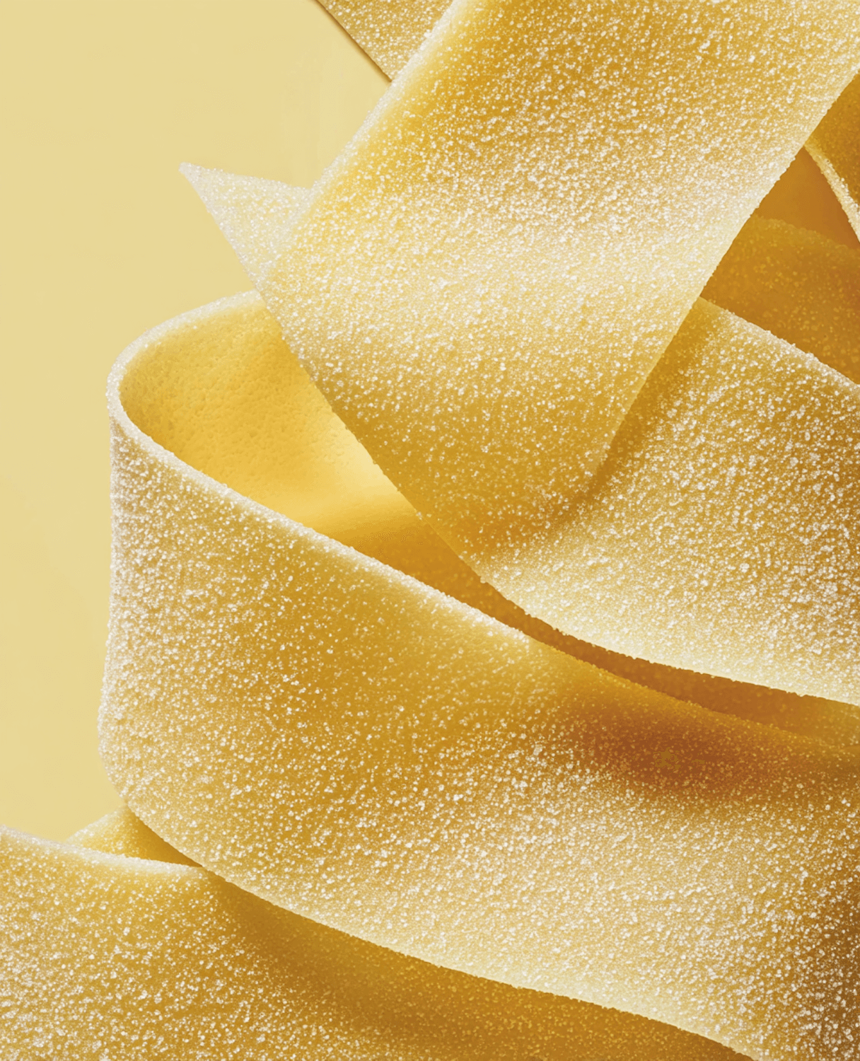 Close-up of fresh, flour-dusted pappardelle ribbons